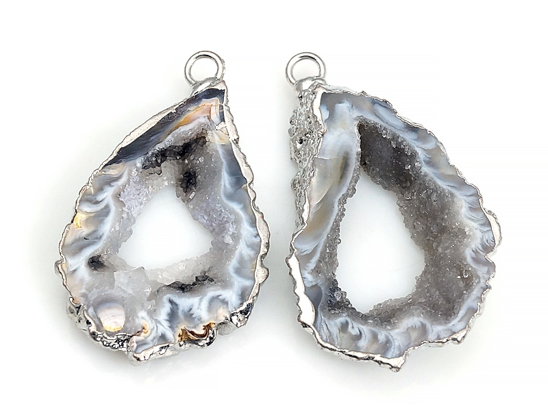 Пара подвесок срезов жеод морозного агата в оправе цвета "серебро". Месторождение - Бразилия. Подвес - 2 мм. Размеры и вес усреднены. Мелкие выемки.
