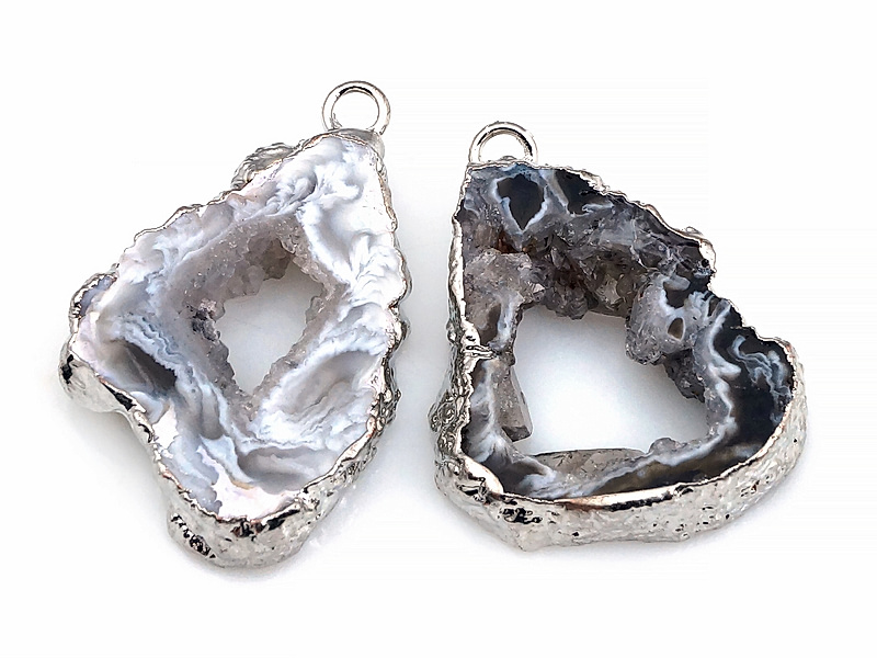 Пара подвесок срезов жеод морозного агата в оправе цвета "серебро". Месторождение - Бразилия. Подвес - 2 мм. Размеры и вес усреднены. Мелкие выемки.
