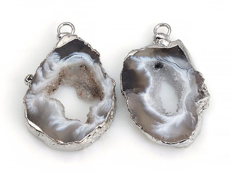 Пара подвесок срезов жеод морозного агата в оправе цвета "серебро". Месторождение - Бразилия. Подвес - 2 мм. Размеры и вес усреднены. Мелкие выемки.
