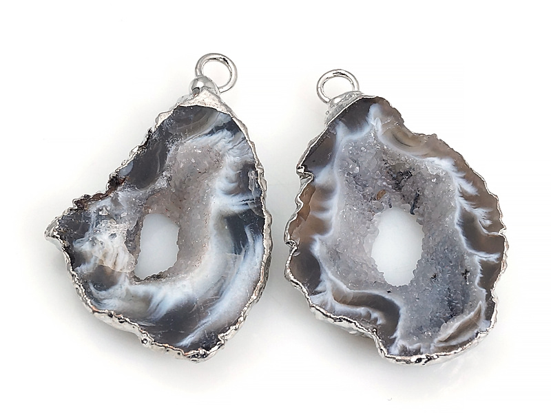 Пара подвесок срезов жеод морозного агата в оправе цвета "серебро". Месторождение - Бразилия. Подвес - 2 мм. Размеры и вес усреднены. Мелкие выемки.
