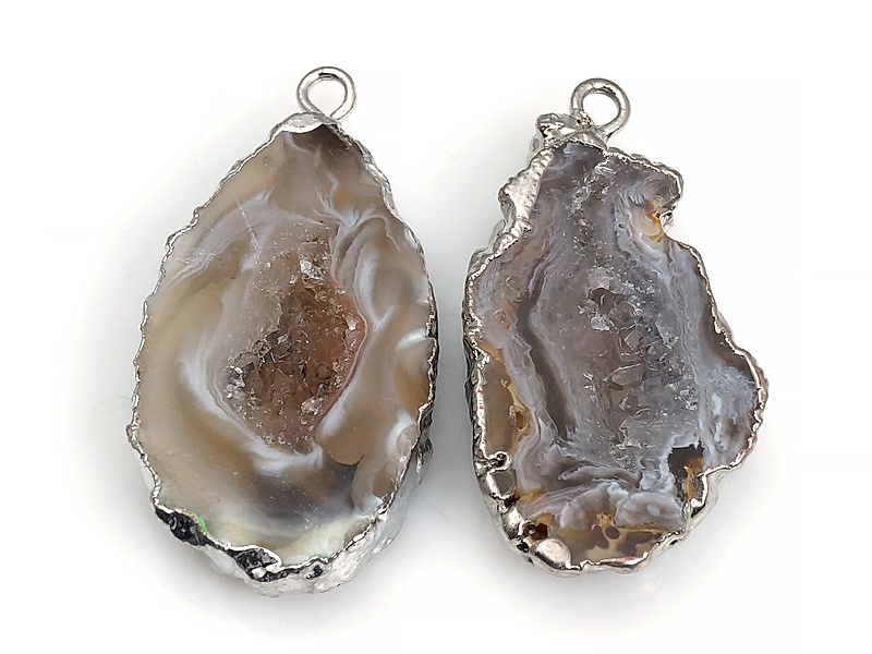 Пара подвесок срезов жеод морозного агата в оправе цвета "серебро". Месторождение - Бразилия. Подвес - 2 мм. Размеры и вес усреднены. Мелкие выемки.
