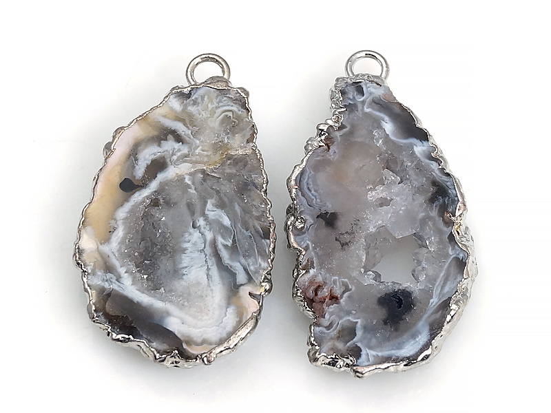 Пара подвесок срезов жеод морозного агата в оправе цвета "серебро". Месторождение - Бразилия. Подвес - 2 мм. Размеры и вес усреднены. Мелкие выемки.
