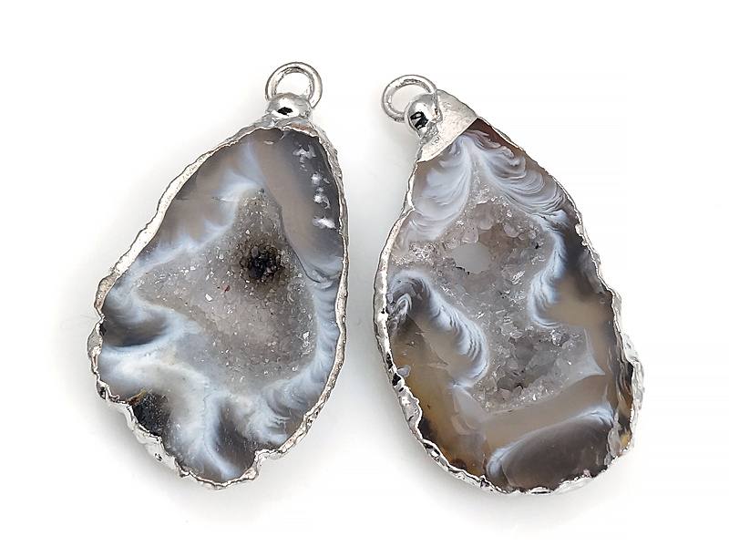Пара подвесок срезов жеод морозного агата в оправе цвета "серебро". Месторождение - Бразилия. Подвес - 2 мм. Размеры и вес усреднены. Мелкие выемки.
