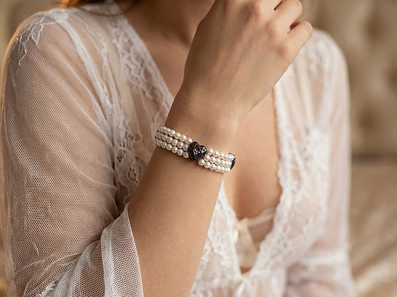 Набор материалов для сборки трёхрядного браслета сочетает белоснежный жемчуг майорку и загадочные чёрные бусины сердечки, внутри украшенные сверкающими кристаллами. Контраст светлых перламутровых рядов и глубокого чёрного акцента создаёт эффект утончённой роскоши.
Как и с чем носить
Жемчуг майорка добавит в ваш образ мягкость и женственность, а сердечки с кристаллами подчеркнут характер и таинственный блеск. Такой браслет станет выразительным акцентом как в вечернем, так и в повседневном гардеробе. Он прекрасно сочетается с маленьким чёрным платьем, шёлковой блузой, лаконичным костюмом или свадебным образом. В повседневных комплектах украшение эффектно дополнит белую рубашку, топ в пастельных оттенках или строгий монохром.
Браслет можно носить соло, подчёркивая его объём и игру света, либо сочетать с тонкими кольцами и серьгами с кристаллами. Это универсальный вариант для романтических встреч, торжеств и особых случаев, когда хочется подчеркнуть изысканность и глубину.
| Интернет-магазин товаров для рукоделия