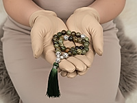 Набор материалов позволит собрать выразительные чётки из зелёного граната гроссуляра — минерала, известного своей природной палитрой и живой фактурой. Бусины обладают мягким, естественным блеском, а игра оттенков — от оливкового до глубокого хвойного — делает изделие визуально объёмным и благородным.&nbsp;
В комплект входят декоративные ажурные бусины, которые создают изящные акценты и формируют выразительный центральный узел. Шёлковая кисть насыщенного зелёного цвета идеально дополняет природную гамму гроссуляра и придаёт чёткам завершённый, аккуратный вид.&nbsp;

Характеристики

Тип изделия: набор для сборки чёток
Основной материал: бусины натурального граната гроссуляра
Диаметр бусин: 10 мм&nbsp;
Фурнитура: ажурные бусины и разделители с фианитами
Кисть: шёлковая, плотная, тёмно-зелёная
Стиль: этника, минимализм, медитативные аксессуары
Назначение: чётки, талисман, авторский аксессуар

С чем и как носить

Чётки из зелёного граната гроссуляра можно использовать как стильный аксессуар, гармонирующий с повседневными и этническими образами, либо как медитативный инструмент для практики концентрации и успокоения.&nbsp;
Их держат в руках, перебирают бусины во время молитвы, медитации или дыхательных упражнений. Благодаря благородной палитре гроссуляра такие чётки подходят и женщинам, и мужчинам, подчёркивают индивидуальность и становятся личным талисманом, который удобно носить с собой в сумке или на запястье, наматывая в несколько рядов.

Мастер - класс, как собрать четки, ЗДЕСЬ.&nbsp;
, фото №161260