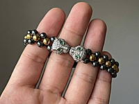 Набор материалов для мужского браслета с двумя выразительными бусинами пантерами - стильное решение для создания украшения своими руками. В комплект входят бусины гематита, акцентные элементы, вощеный шнур для плетения по классической схеме шамбала.&nbsp;

Мастер - классы, как плести браслеты шамбала, ЗДЕСЬ.&nbsp;

Контраст темно-серого, золотого и серебряного оттенков подчеркивает характер, а пантеры придают браслету силу и статус. Идеально для подарка мужчине.

Ширину браслета можно менять, прибавляя либо убавляя количество шнуров, бусины и фурнитура также могут быть заменены на любые другие по форме, цвету и расположению.&nbsp;

, фото №163012