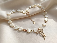 Набор материалов для чокера с перламутровыми бусинами сердечками и красивой подвеской бантиком - украшение с романтичным настроением.&nbsp;

Мастер - класс, как собрать чокер на тросик, используя калоты и кримпы, ЗДЕСЬ.&nbsp;

Основа сборки - ювелирный тросик. Длина украшения регулируется цепочкой удлинителем на замочке карабине.&nbsp;

Как и с чем носить

Чокер можно носить с легкими летними платьями, блузами, открытыми топами или жакетом с глубоким вырезом. Перламутр красиво подчеркивает тон кожи и добавляет образу сияние, поэтому украшение одинаково хорошо смотрится как в дневных, так и в вечерних образах. Такой чокер станет изящным акцентом, который подчеркнет женственность и романтичный стиль.
, фото №163434