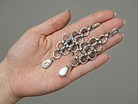 Набор материалов позволяет собрать оригинальные винтажные серьги с рифленой фактурой металла и каплями натурального жемчуга. В композиции используются элементы ювелирной цепочки шторки, соединительные колечки и бусины жемчуга, которые формируют ажурную подвижную конструкцию.&nbsp;

Урок, как правильно открывать и закрывать соединительные колечки, чтобы собрать это украшение, ЗДЕСЬ.&nbsp;

Как и с чем носить

Рифленые колечки цепи создают характерный винтажный орнамент, а жемчуг добавляет мягкий благородный блеск и завершает силуэт украшения. Серьги гармонично дополняют образы в стиле винтаж, арт - деко и элегантный минимализм. Они красиво сочетаются с однотонными платьями, шелковыми блузами, жакетами и вечерними нарядами с открытой линией шеи.&nbsp;
, фото №163454