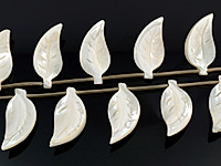 Резные бусины листочки белого перламутра.  Месторождение - Индонезия. Диаметр отверстия 1 мм. Размеры, вес, длина и количество бусин на нити указаны примерно. Точнее замеряем по требованию.Природные неровности.
, фото №163780